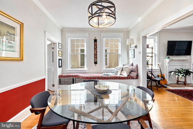 dining room with baseboards, wood finished floors, and crown molding