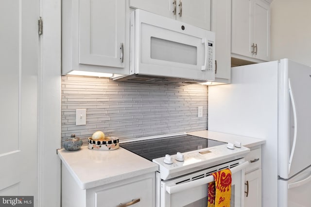 kitchen with white appliances, light countertops, backsplash, and white cabinetry