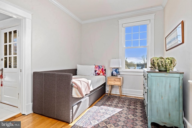 bedroom featuring baseboards, ornamental molding, and wood finished floors