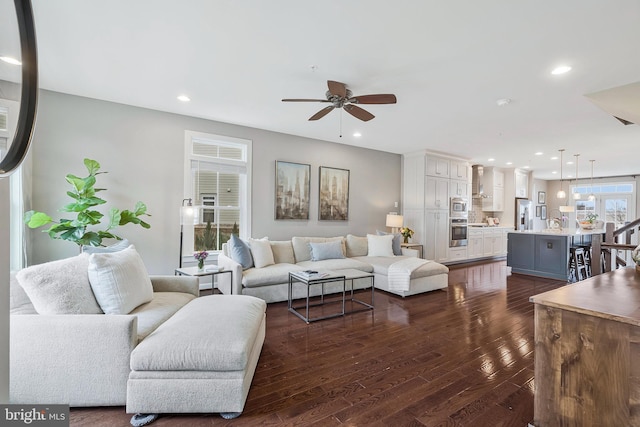 living room with dark wood-type flooring and ceiling fan