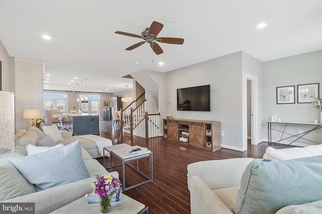 living room featuring dark hardwood / wood-style flooring and ceiling fan with notable chandelier