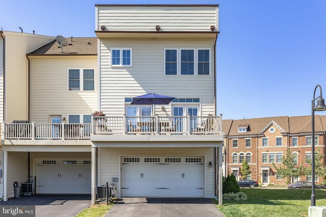 rear view of property with central AC and a lawn