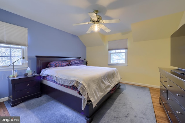 bedroom with hardwood / wood-style flooring, ceiling fan, and vaulted ceiling