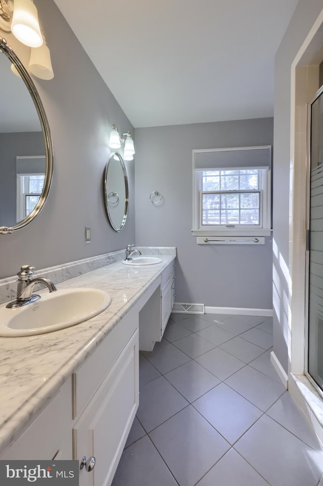 bathroom with tile patterned flooring, vanity, and a shower with door