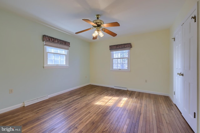 unfurnished bedroom featuring multiple windows, dark hardwood / wood-style floors, and ceiling fan