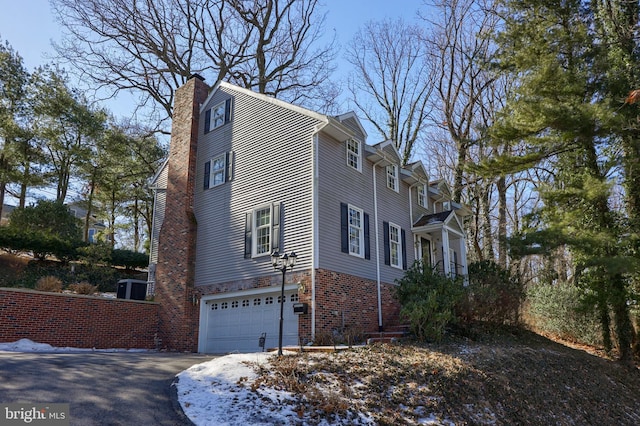 view of snowy exterior with a garage