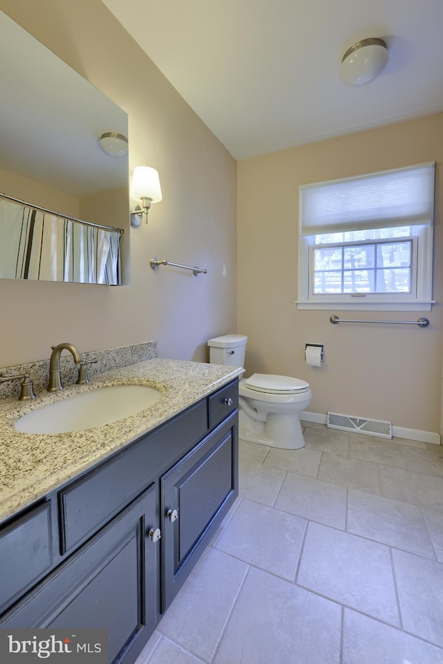 bathroom featuring vanity, toilet, and tile patterned flooring