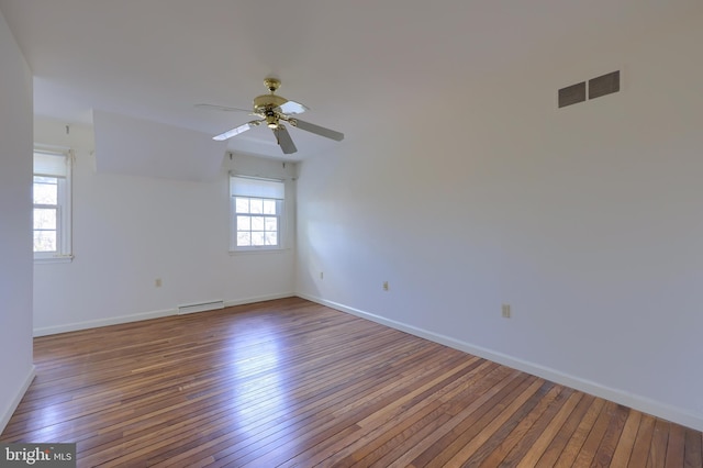 spare room featuring a baseboard radiator, hardwood / wood-style floors, and ceiling fan