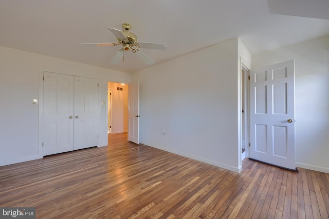 unfurnished bedroom with wood-type flooring, ceiling fan, and a closet