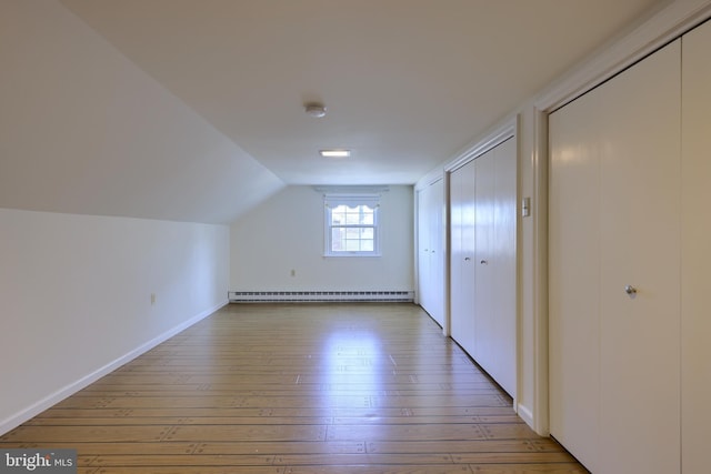 bonus room featuring a baseboard radiator, wood-type flooring, and vaulted ceiling