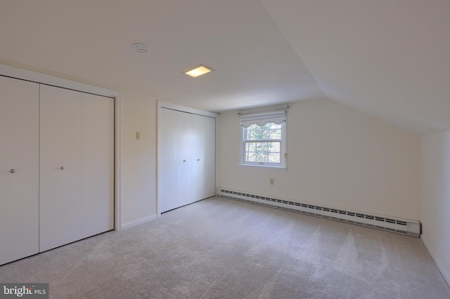 additional living space featuring lofted ceiling, a baseboard radiator, and light colored carpet