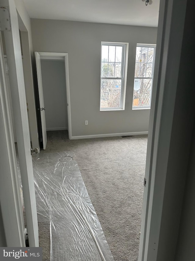 interior space featuring carpet flooring, visible vents, and baseboards