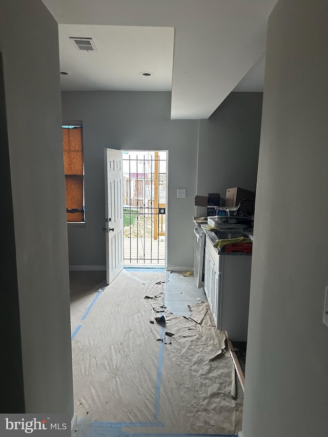 kitchen with dark countertops, a sink, visible vents, and baseboards