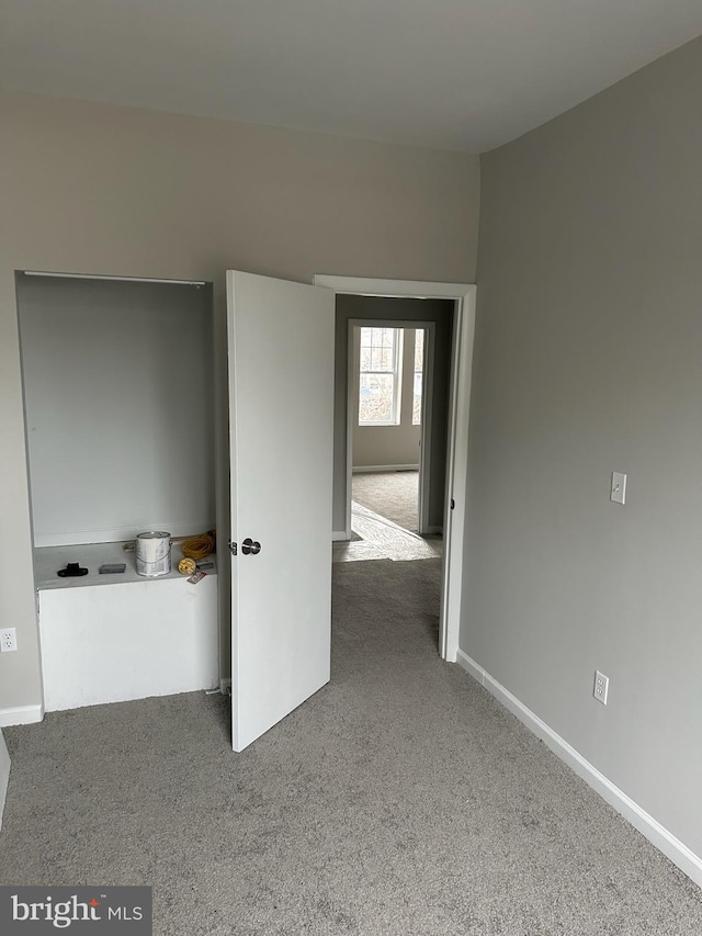 interior space featuring baseboards and carpet flooring