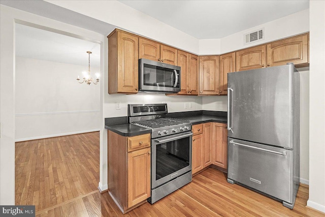 kitchen featuring dark countertops, visible vents, appliances with stainless steel finishes, and light wood-style flooring