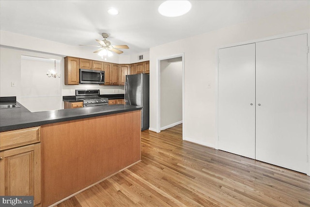 kitchen with stainless steel appliances, dark countertops, light wood-type flooring, and ceiling fan