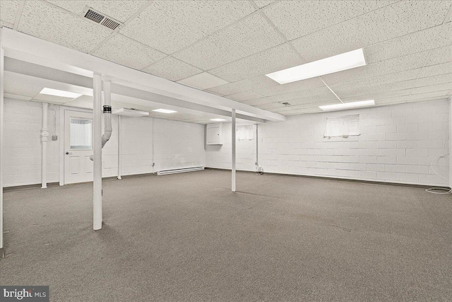 finished basement with a drop ceiling, visible vents, and concrete block wall