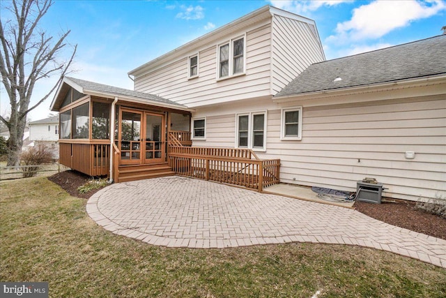 back of house featuring roof with shingles, a patio, a lawn, a sunroom, and fence