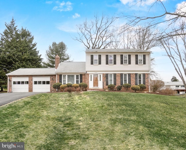 colonial home with brick siding, driveway, a chimney, and an attached garage