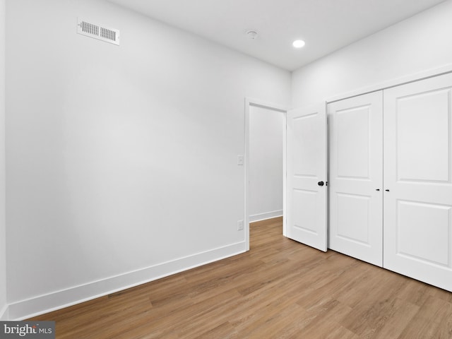 unfurnished bedroom featuring light hardwood / wood-style floors and a closet