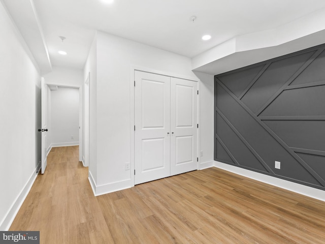 unfurnished bedroom featuring light wood-type flooring and a closet