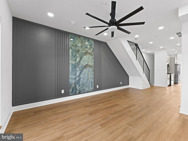 unfurnished living room featuring ceiling fan and light wood-type flooring