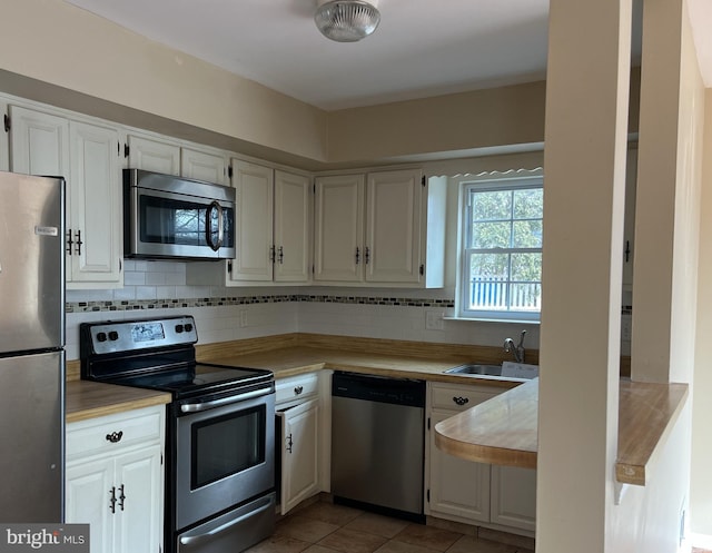 kitchen with sink, white cabinets, and appliances with stainless steel finishes