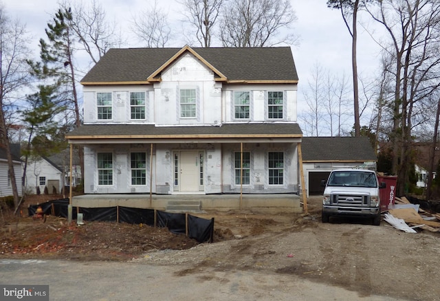 view of front of property featuring covered porch, roof with shingles, and driveway