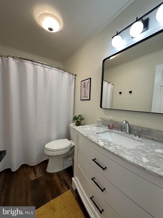 bathroom with crown molding, wood-type flooring, toilet, and vanity