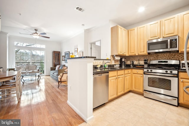 kitchen with ornamental molding, appliances with stainless steel finishes, sink, and decorative backsplash