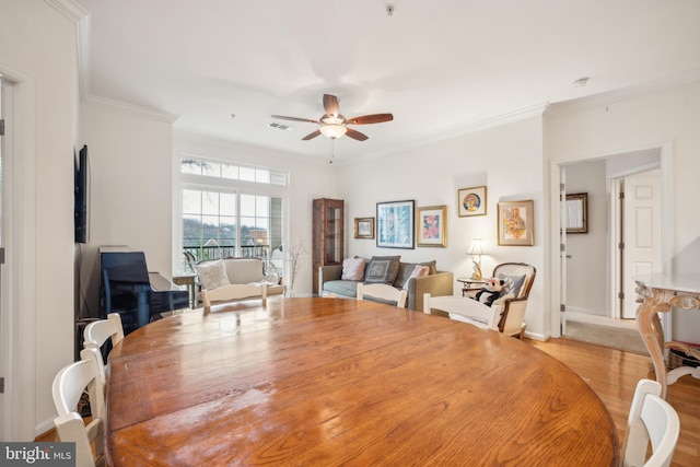 dining room featuring crown molding, light hardwood / wood-style floors, and ceiling fan