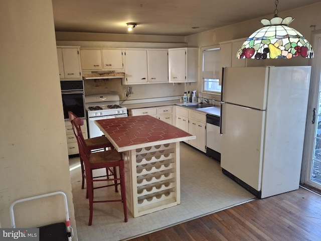 kitchen featuring white cabinetry, white appliances, and hanging light fixtures