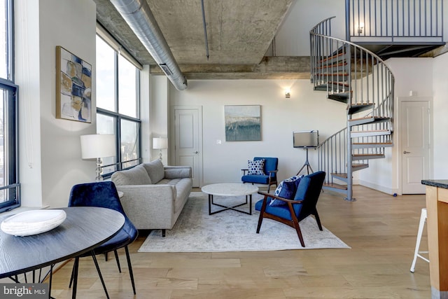 living room featuring a towering ceiling and light hardwood / wood-style floors