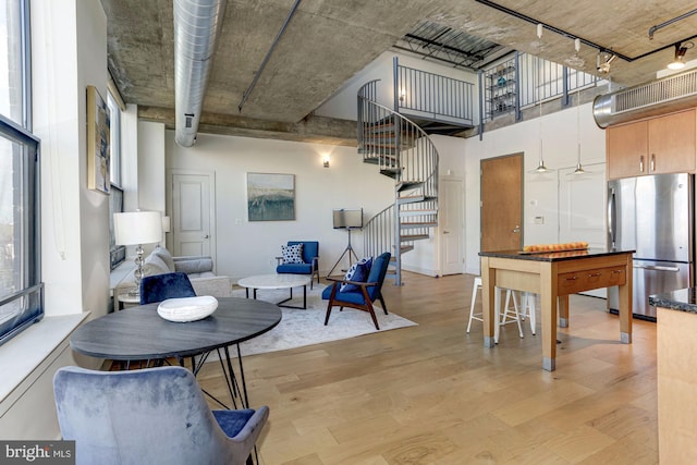 interior space featuring a towering ceiling and light wood-type flooring