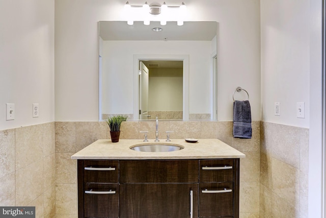 bathroom with vanity and tile walls