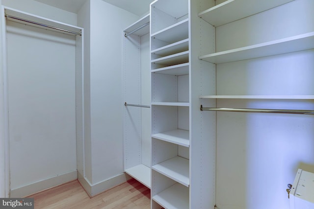 walk in closet with light hardwood / wood-style flooring