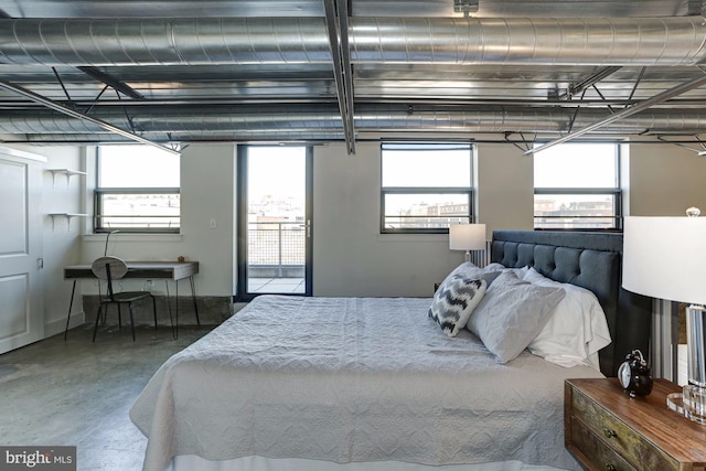 bedroom featuring access to outside and concrete floors