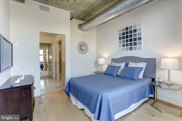 bedroom featuring hardwood / wood-style floors and ensuite bath