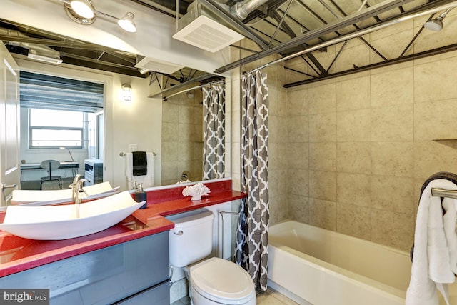 full bathroom featuring shower / bath combination with curtain, vanity, and toilet