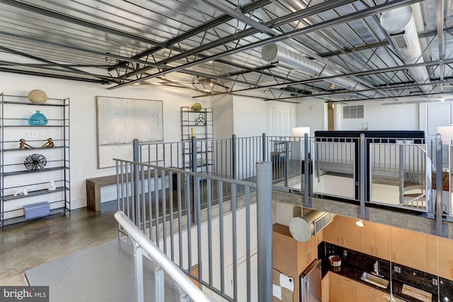 hall featuring concrete flooring and sink