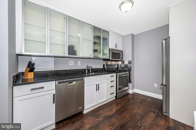 kitchen featuring white cabinetry, stainless steel appliances, sink, and dark stone countertops