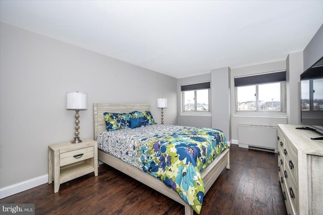 bedroom with dark hardwood / wood-style flooring and radiator