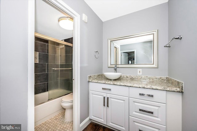 full bathroom featuring enclosed tub / shower combo, vanity, and toilet