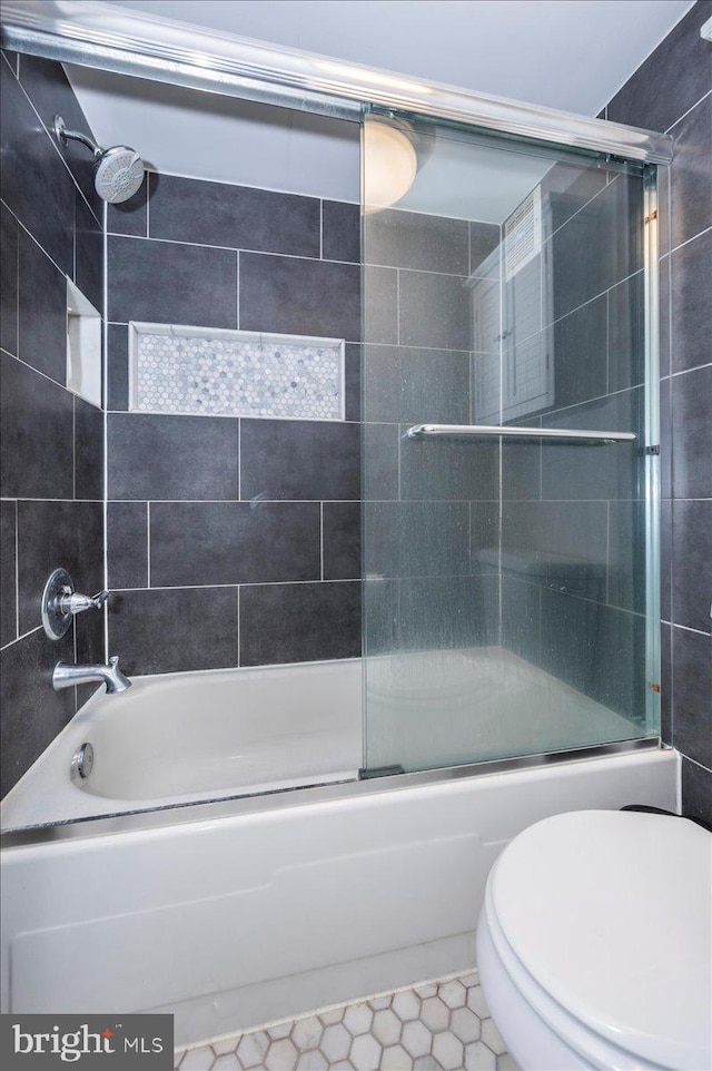 bathroom with enclosed tub / shower combo, tile patterned floors, and toilet