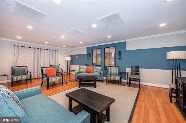 living room featuring crown molding and light hardwood / wood-style flooring