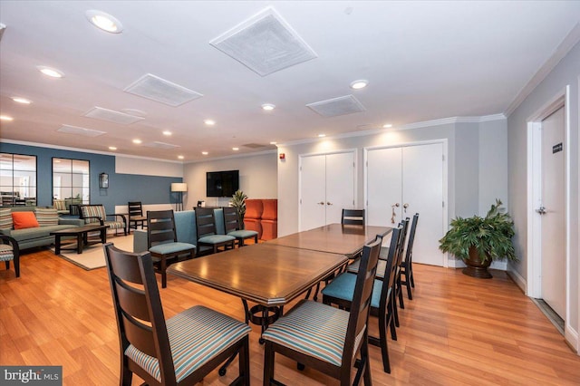 dining space with ornamental molding and light wood-type flooring