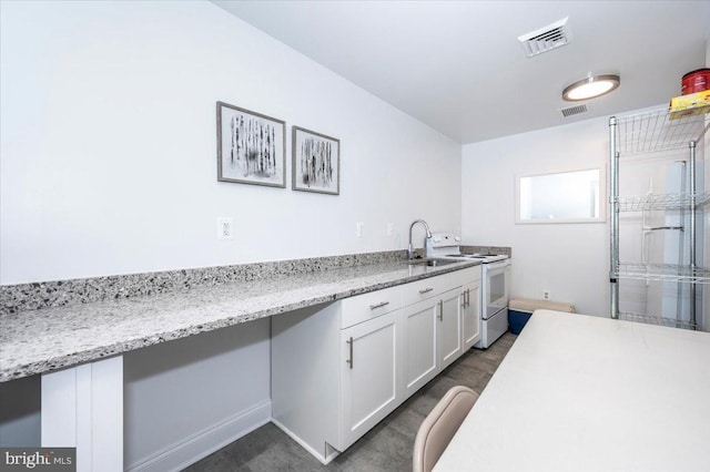 kitchen with white cabinets, light stone countertops, sink, and electric range