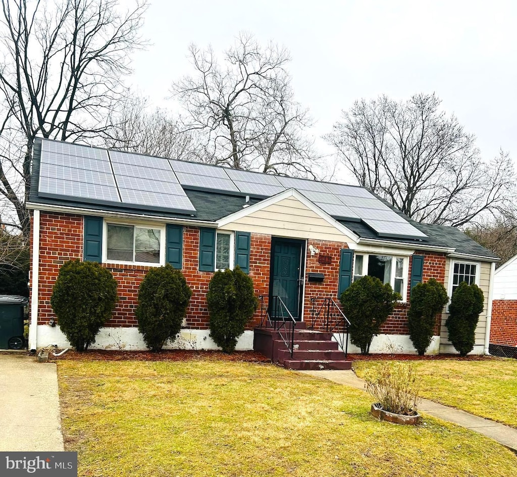 view of front of house with a front yard and solar panels