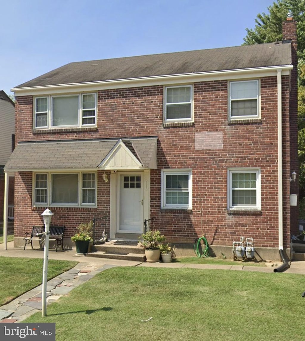 view of front of home with a patio area and a front yard