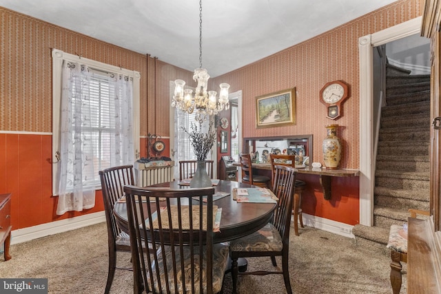 carpeted dining space featuring a healthy amount of sunlight and a chandelier